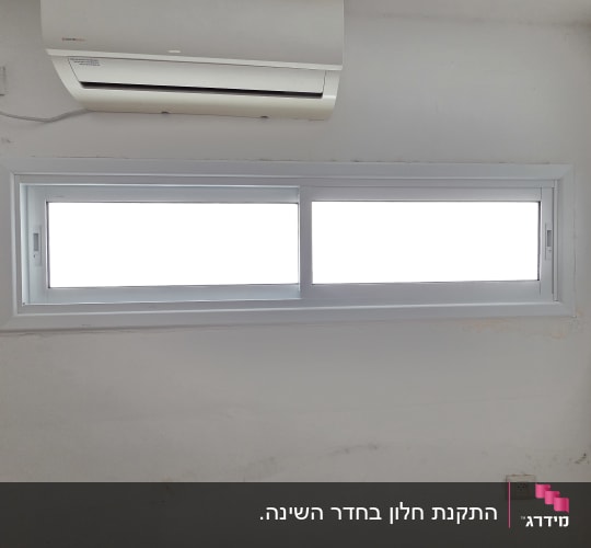 חלון אלומיניום הזזה לבן מותקן על קיר בחדר